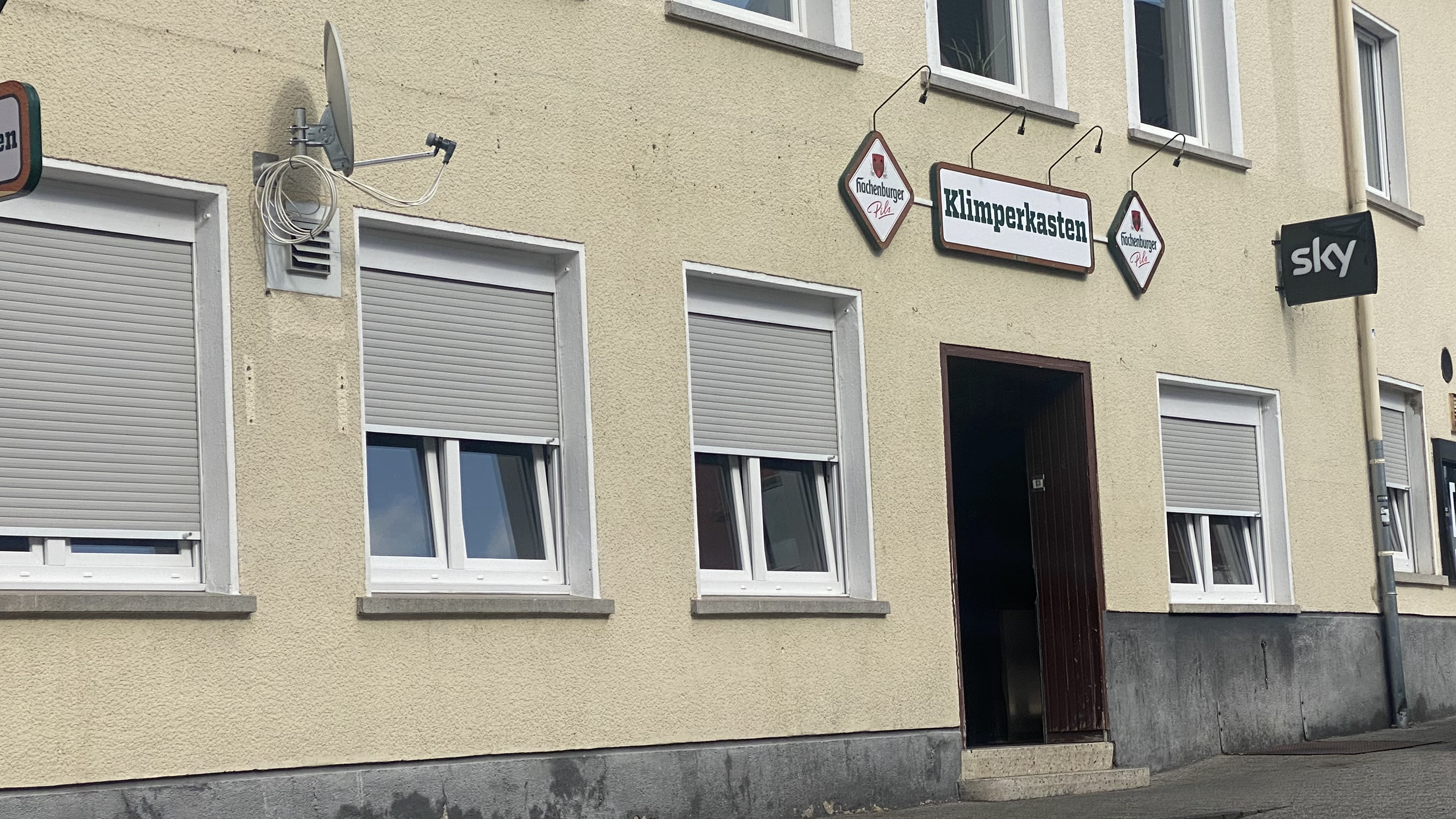Aussenansicht des 'Klimperkasten', eines lokalen Gewerbebetriebs in Westerburg, mit Schildern für Hachenburger Pils und Sky – repräsentativ für die regionale Wirtschaftsförderung durch den Gewerbeverein Westerburg.
