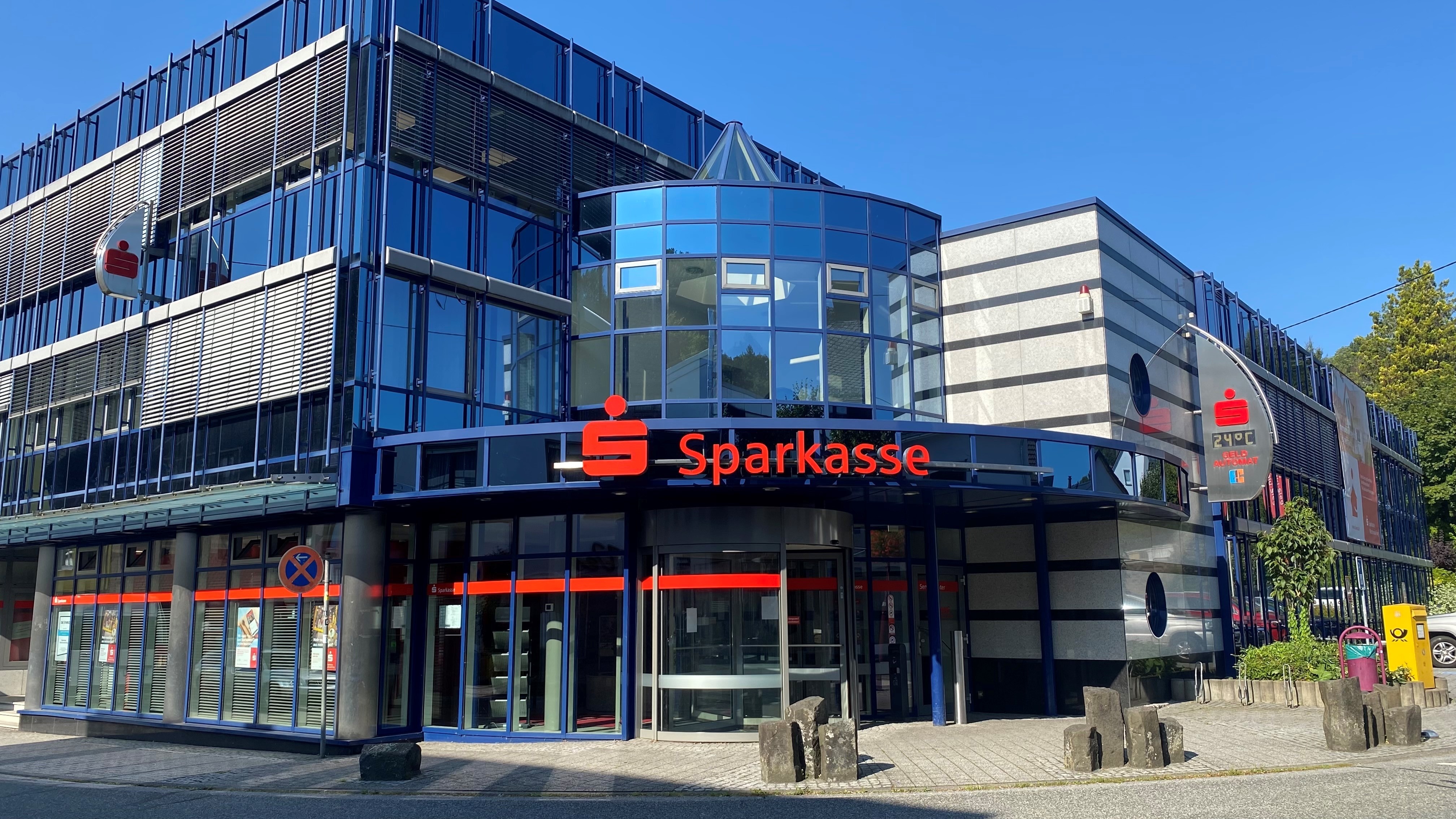 Modernes Sparkasse-Gebäude mit Glasscheibenfassade und rotem Logo in Westerburg, Teil des Wirtschaftsstandorts, den der Gewerbeverein Westerburger Land fördert.