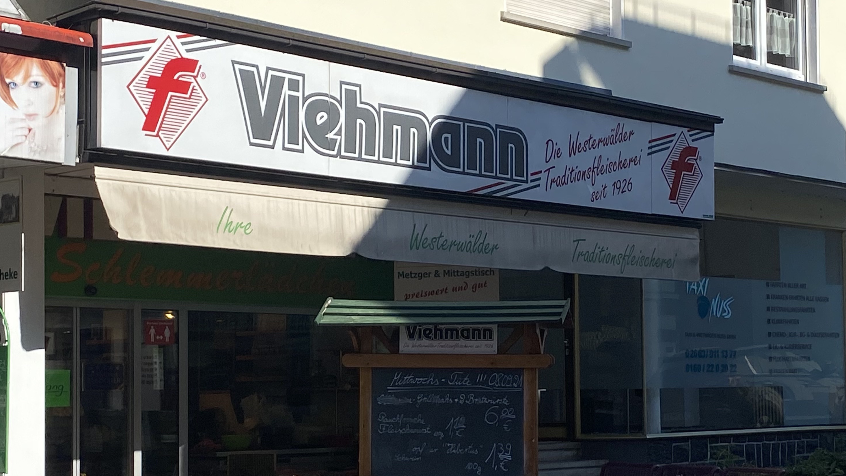 Viehmann Metzgerei, Westerwälder Traditionsfleischerei seit 1926, mit Ladenfrontschild und Aushängen, die das Metzgerhandwerk und lokale Angebote präsentieren.