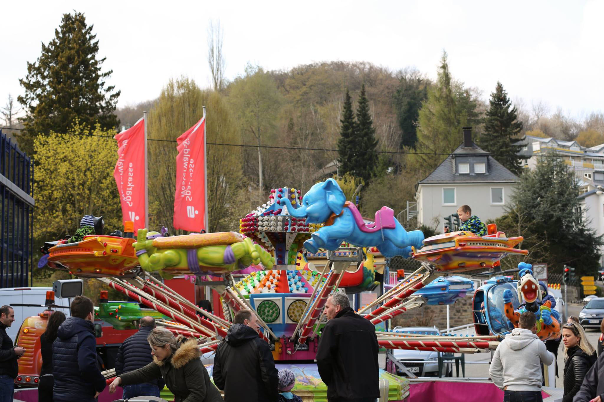 Farbige Karussellfahrt mit Tierfiguren (Elefant) auf einem öffentlichen Event in Westerburg, umgeben von Besuchern und lokalen Gebäuden – Teil der Veranstaltungen des Gewerbevereins Westerburger Land zur Förderung des regionalen Wirtschaftsstandorts.