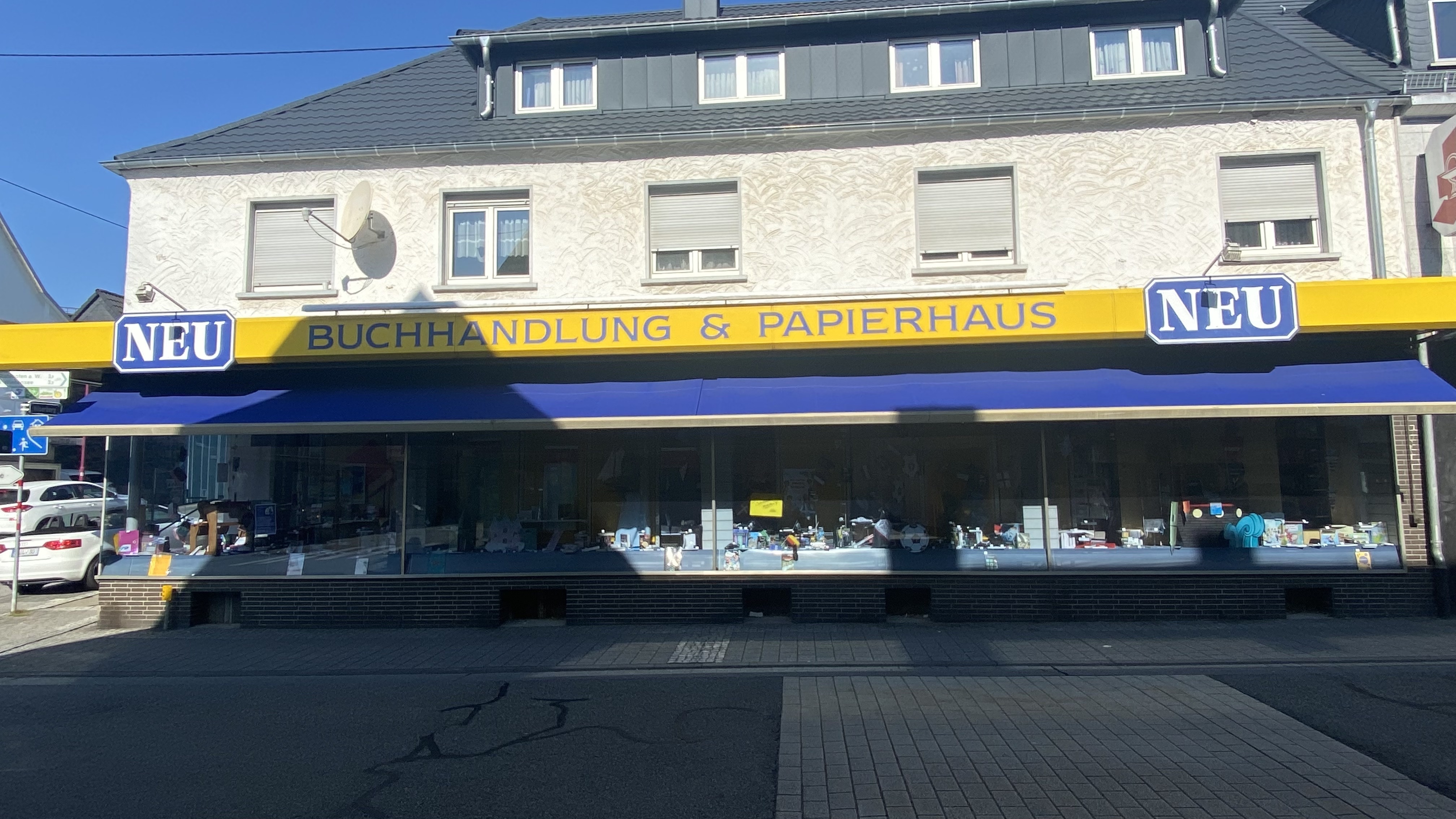 Fassade eines Buch- und Papierladens mit gelbem Schild 